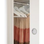 Vue rapprochée d'une porte coulissante en bois avec poignée rondo donnant sur dressing