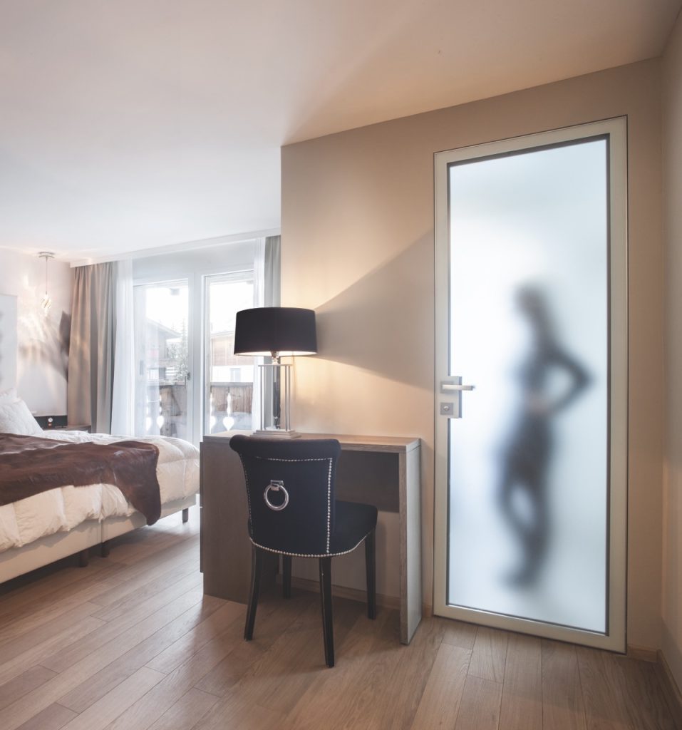 Une porte battante affleurante en verre et aluminium