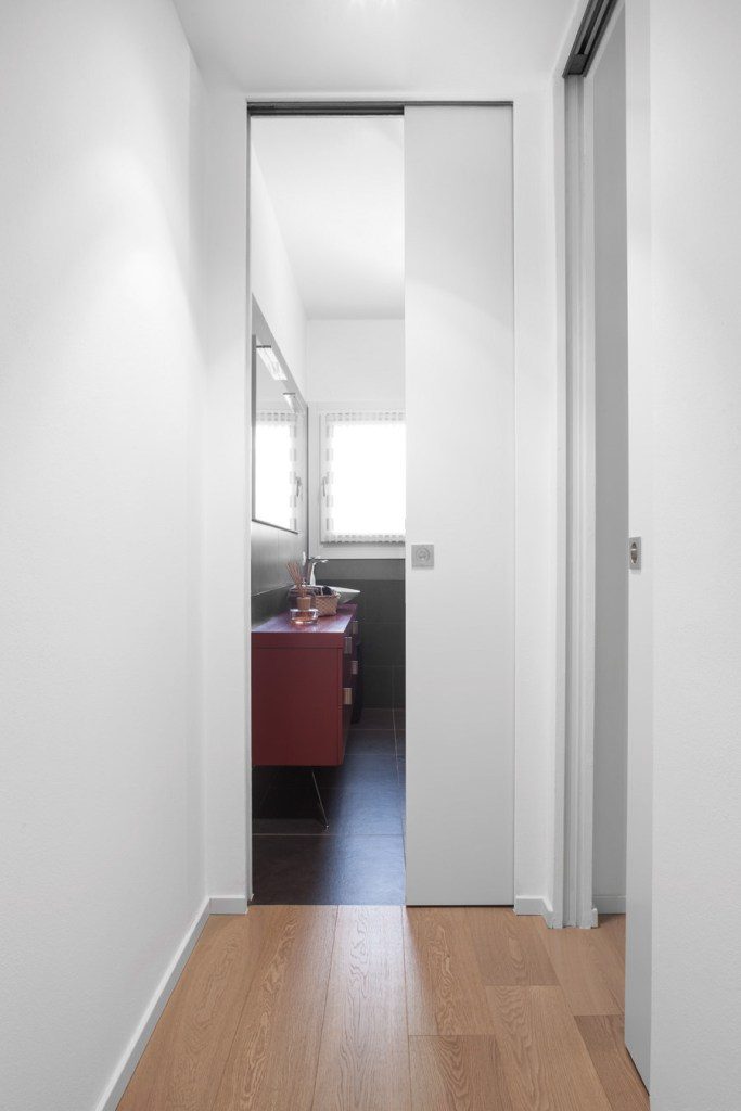 Une porte coulissante en bois dans son châssis à galandage Syntesis