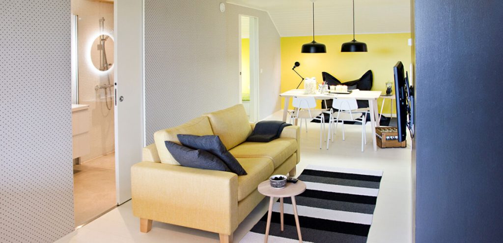 Un espace aménagé en longueur avec un mur jaune au fond.