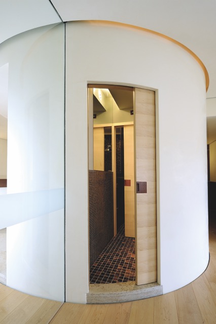 Une porte coulissante courbe épouse parfaitement la cloison incurvée dans cette rénovation d'appartement