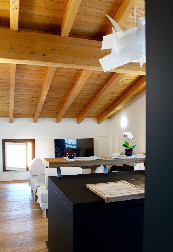 Vue du salon depuis la cuisine de ce projet d'aménagement en mansarde