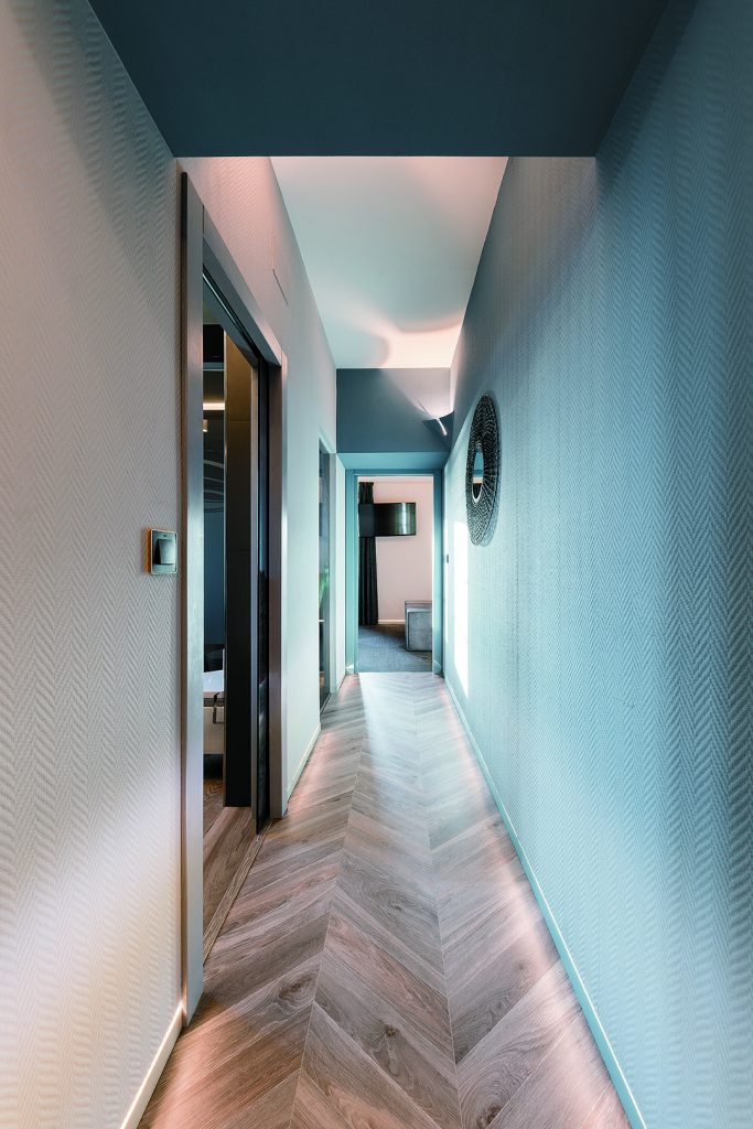 Couloir habillé des supports de plinthes Syntesis affleurantes à la cloison avec LED intégré