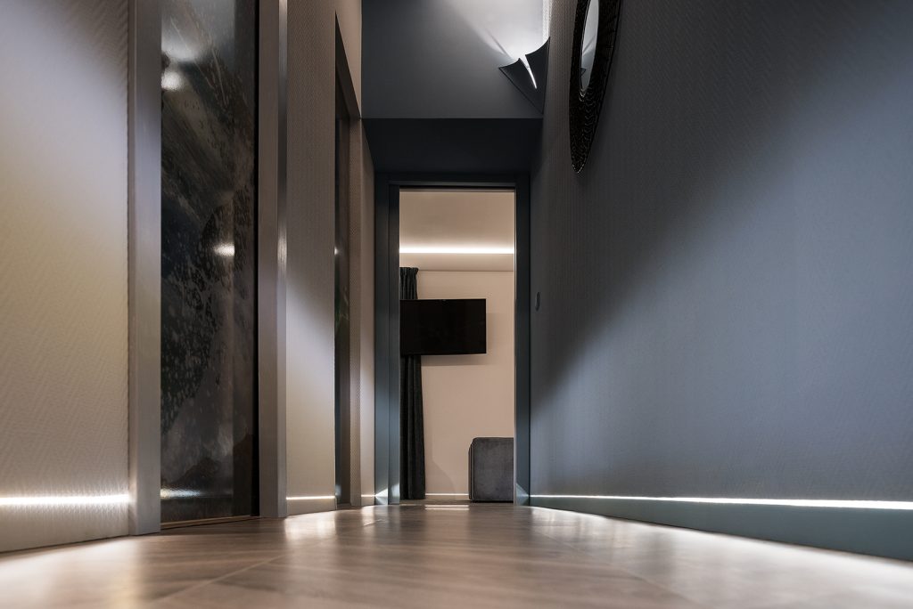 Un couloir illuminé par les supports de plinthes à fleur de cloison Syntesis