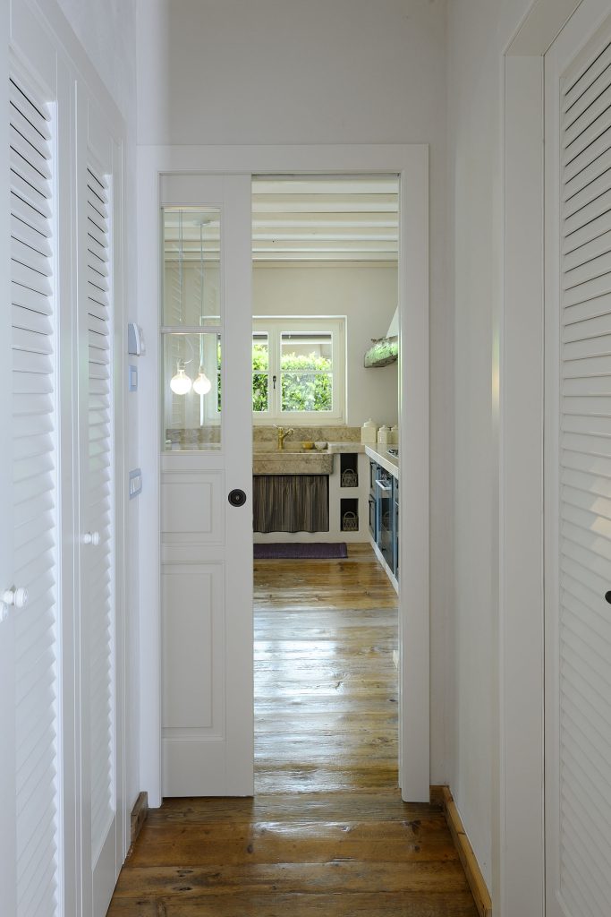 Portes coulissantes en bois avec inserts en verre entre le salon et la cuisine