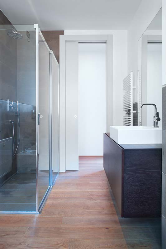 Un espace salle de bain dissimulé par une porte coulissante ECLISSE modèle Unique