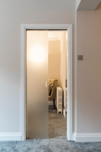 gagner des mètres carrés grâce à une porte coulissante Eclisse modèle Unique avec porte tout verre.