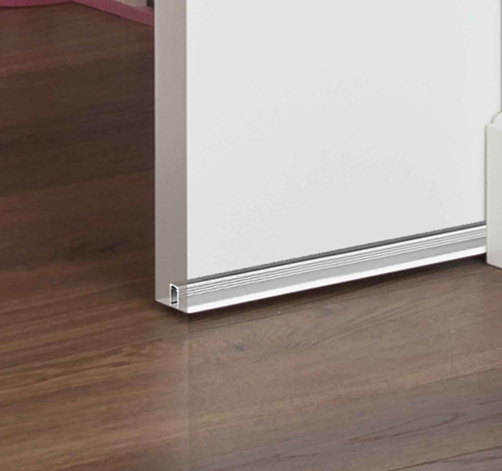 Profil Security ECLISSE qui protège la rainure d'une porte coulissante en bois.