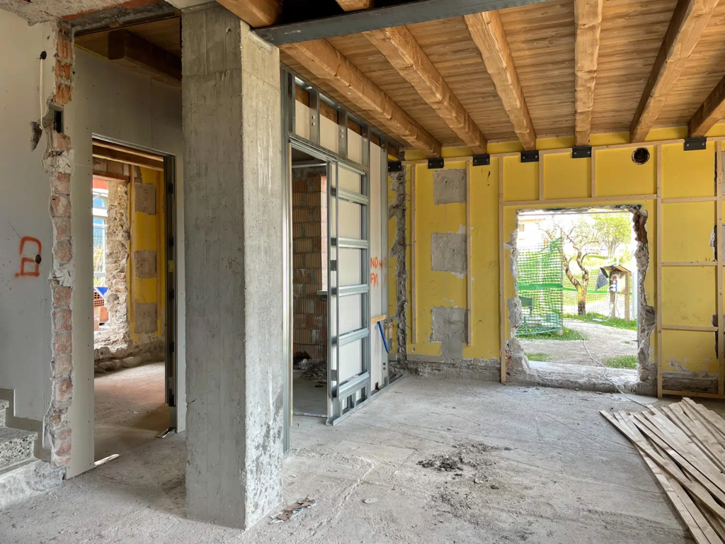 Chantier de rénovation du salon d'une ferme vénitienne, châssis qui s'insère dans les rails de la cloison pour accueillir plus tard une porte coulissante