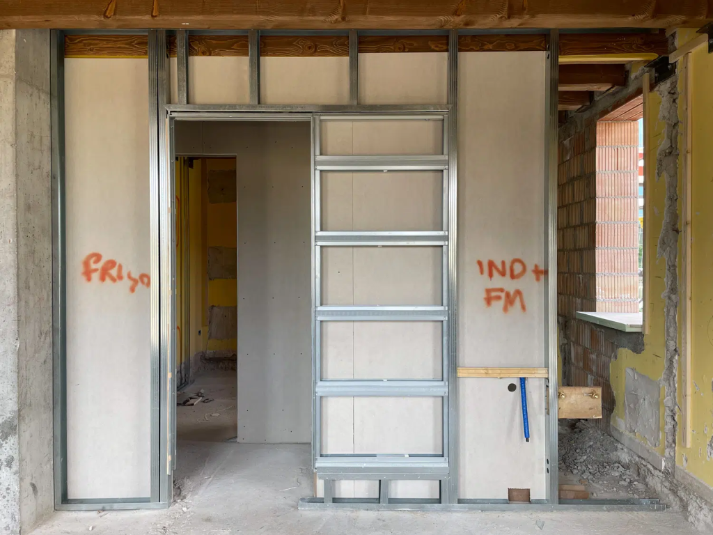 Chantier de rénovation d'une ferme vénitienne, châssis qui s'insère dans les rails de la cloison pour accueillir plus tard une porte coulissante